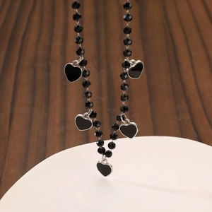 Close-up of gothic beaded necklace with black heart pendants and silver metallic frames