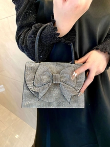 Close-up of sparkling silver rhinestone evening bag with luxury crystal bow decoration