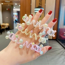 Detailed shot of spiral telephone cord hair rings decorated with colorful faux pearls