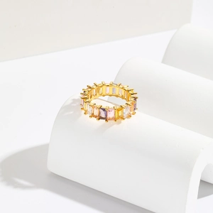 Luxurious gold ring with baguette-cut multi-color crystals on white stone pedestals