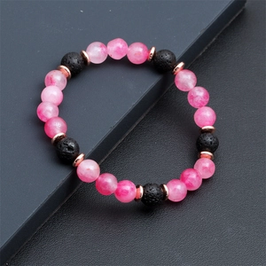 Dettaglio di bracciale con pietre occhio di gatto rosa e perle di lava vulcanica
