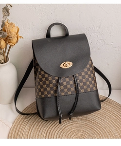 Close-up of retro color-block backpack with monogram pattern and gold metal twist lock