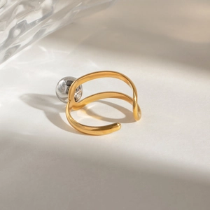 Detail of two-tone open ring featuring a silver sphere accent on a gold-plated steel band