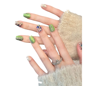 Fresh green cat eye press-on nails with blue sparkles and white pearls on hands
