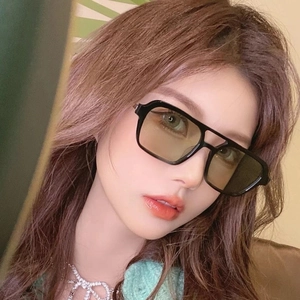 Close-up of retro double-bridge pilot sunglasses with black frames and yellow tinted lenses