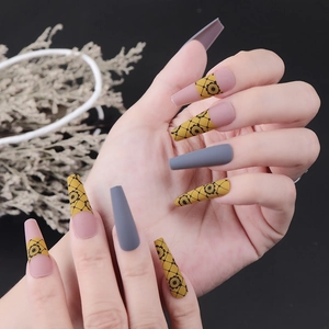 Matte grey and yellow flower long ballerina press-on nails shown on model hand