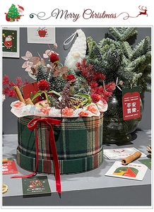 Close-up of a festive Christmas round gift box with gnome and red berry decorations