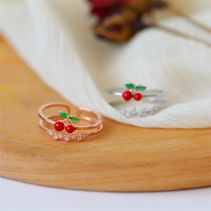 Dettaglio degli anelli a ciliegia con zirconi in finitura oro rosa e argento per donna