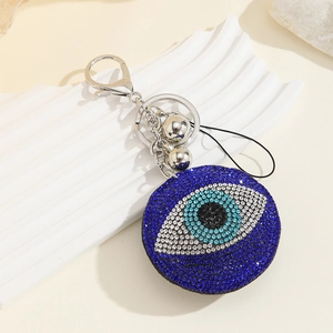 Blue rhinestone Turkish Evil Eye keychain with silver hook and tassel on white background