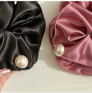 Detail of black and pink silk scrunchies with large pearl accents for ponytails