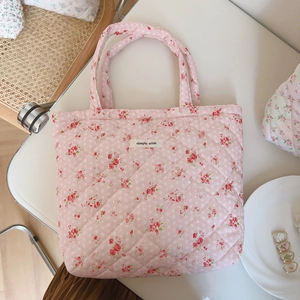 Detailed macro view of pink floral quilted tote bag with a simple wish fabric label