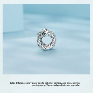 Close-up of S925 sterling silver coiled snake bead with green gemstone eye detail