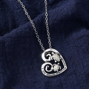 Macro shot of heart turtle pendant with I love you forever engraving detail