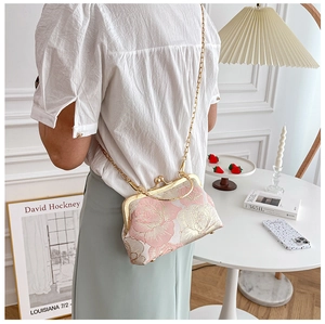 Detail of pink floral cheongsam clutch with gold metal frame and chain strap