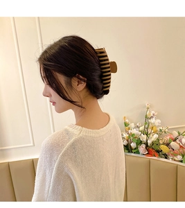 Elegant oversized brown matte hair claw clip shown from side view on model's hair