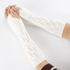 Close-up of white cable knit fingerless gloves showing detailed arm warmer texture