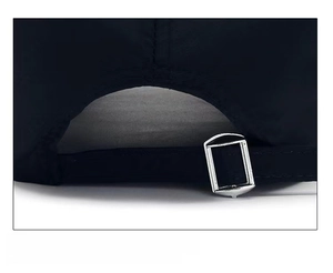 Detail of adjustable silver metal buckle on black printed baseball cap with long brim