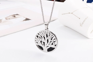 Silver Tree of Life necklace pendant with black inlay on a white lifestyle background