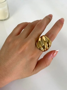 Vue détaillée d'une grosse bague torsadée en acier plaqué or 18 carats portée à la main