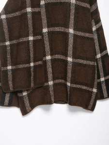 Detailed close-up of brown plaid knitted cardigan showing wool blend fabric texture