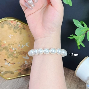Close-up of 12mm white pearl bracelet worn on wrist with vintage French style design