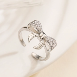 Macro shot of silver bow ring with shimmering cubic zirconia and adjustable open band