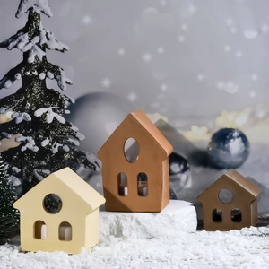 Trois moules de bougeoirs en forme de nichoir dans une scène de neige pour Noël