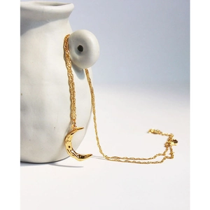 Elegant gold brass moon pendant necklace with handcrafted texture on white ceramic background