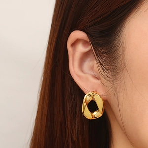 Orecchini geometrici irregolari in acciaio al titanio placcati oro 18K su modella