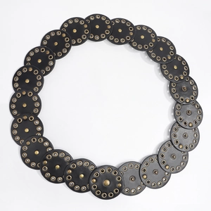 Detail of black leather punk belt with round discs and bronze metal rivets on white background