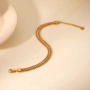 Detail of gold multilayer stainless steel bracelet with white zircon and S.Steel hallmark