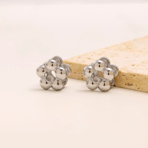Detailed view of silver stainless steel flower earrings with small spheres on stone base