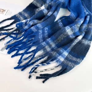 Macro detail of soft blue plaid mohair scarf with fuzzy fringe and warm texture