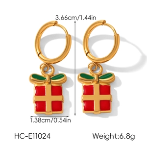 Détail de boucles d'oreilles de Noël dorées avec pendentif cadeau rouge et vert et taille