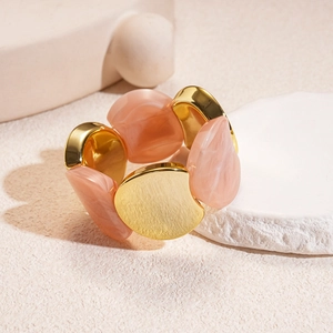 Dettaglio di blocchi in resina marmo rosa e parti metalliche dorate lucide su base ruvida