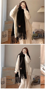 Detail shot of a soft black tassel scarf with a vintage brown label for a cozy winter look