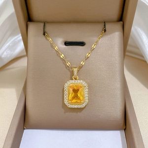 Gros plan du collier en acier titane avec pierre jaune carrée dans un coffret cadeau