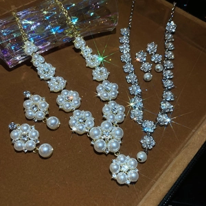 Detailed macro view of gold and silver flower jewelry sets with pearls and crystals