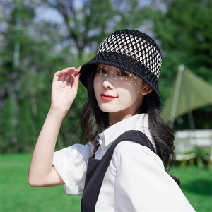 Women's woven hollow straw bucket hat in black and white for sun protection