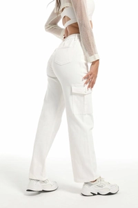 Detail of high waist white cargo jeans featuring side pockets and cotton denim texture