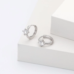 Detailed view of silver hoop earrings with clear round cubic zirconia on a white stand