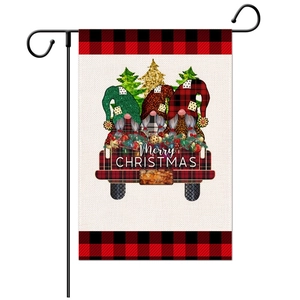 Detail of Christmas garden flag featuring festive gnomes and a vintage red truck on burlap