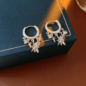 Detailed view of silver star earrings with zircons on a luxury blue jewelry box
