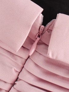 Close-up of pink textile fabric showing a high-quality invisible zipper and pleated details
