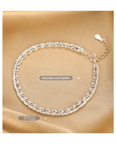 Nahaufnahme des zweilagigen S925 Sterlingsilber-Armbands mit Perlen auf goldenem Seidenstoff