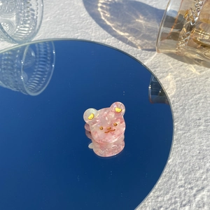 Gros plan d'une pince à cheveux ours en acétate marbré rose avec ombres solaires