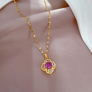Détail du collier en titane doré avec pendentif trèfle rose et cristaux de zircon