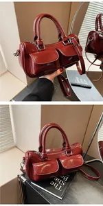 Detail view of deep red glossy saddle bag with dual front pockets and silver hardware