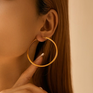 Minimalist 18K gold plated brass hoop earrings shown on model in warm lighting