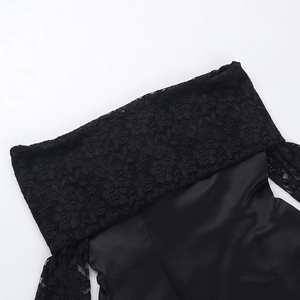 Detail aus schwarzer Spitze und Satinstoff eines schulterfreien Bodycon-Kleides